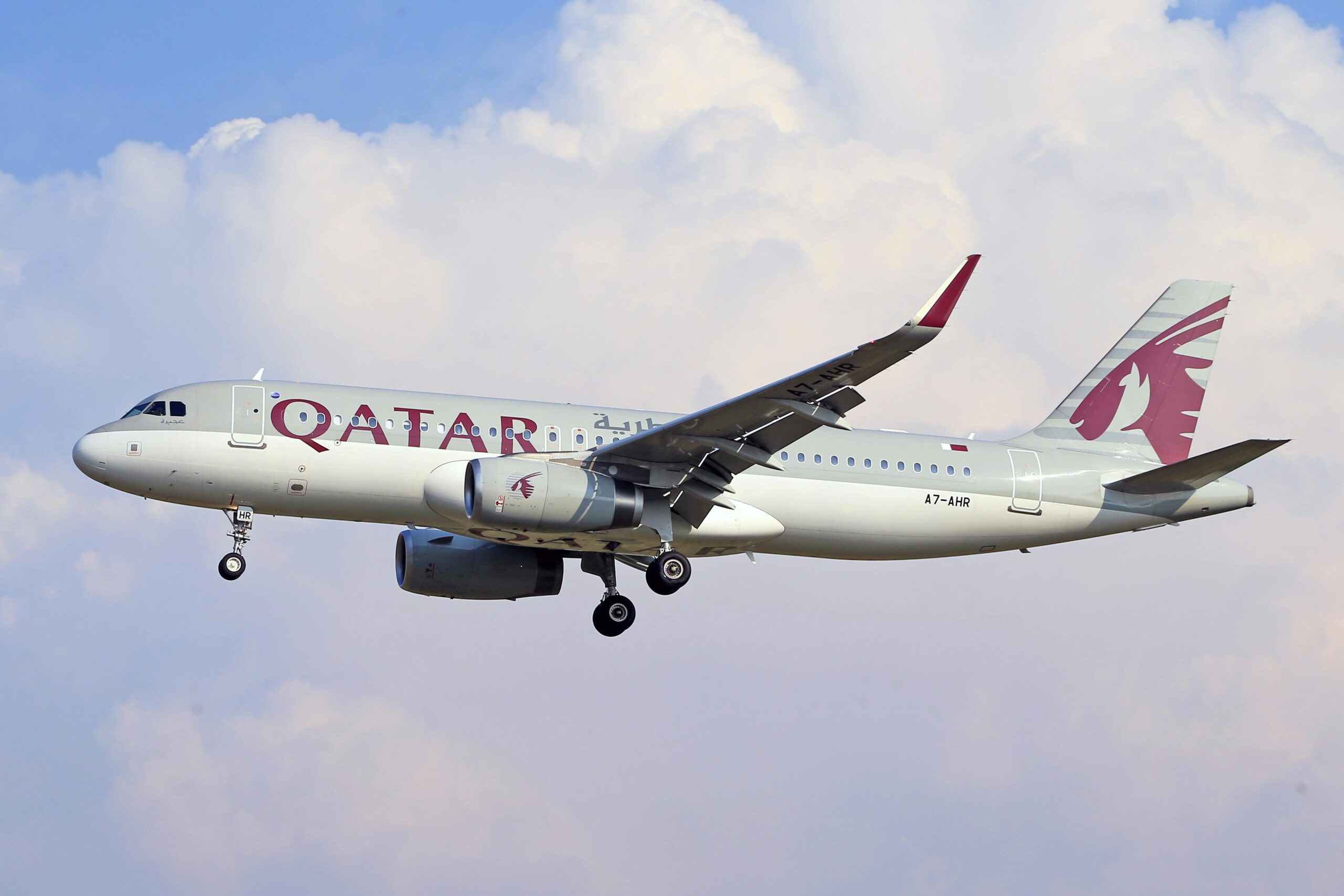 A Qatar Airways plane flying in the sky.